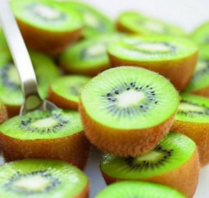 展示绿心猕猴桃（左侧）与黄心猕猴桃（右侧）的切面对比，绿心果肉呈翠绿色，黄心果肉呈金黄色，果形略有差异